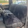 a black sheepskin seat cover installed on the back seat of a truck.