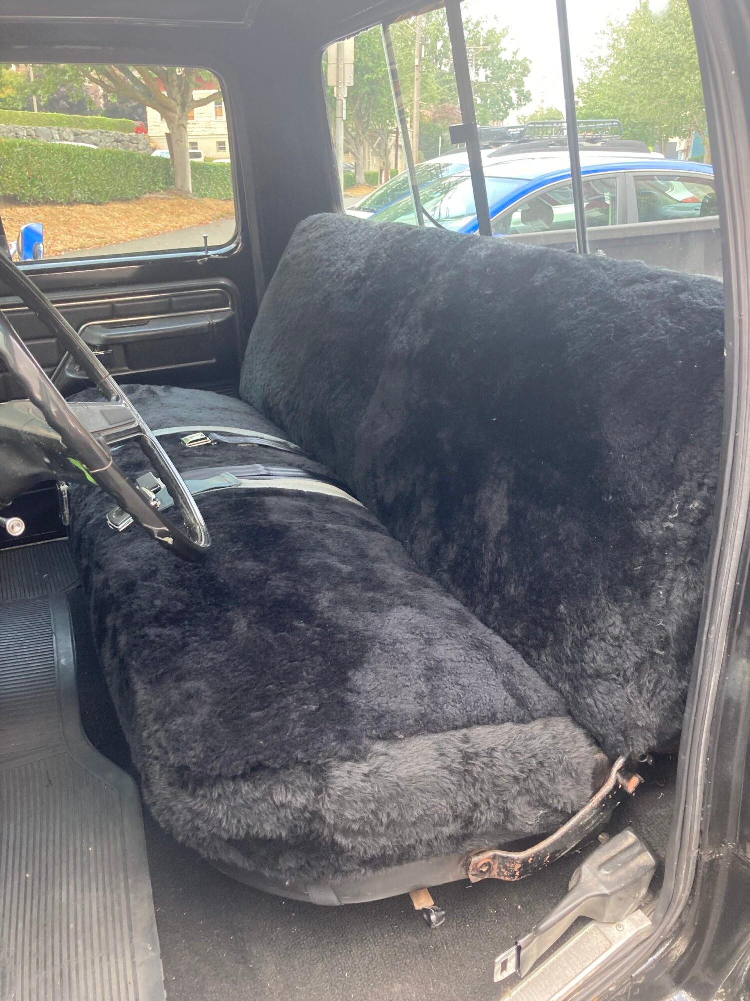 a black sheepskin seat cover installed on the back seat of a truck.