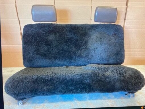 a black sheepskin seat cover for a car's back seat