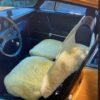 a classic Porsche 911. The car has a tan interior with sheepskin seat covers.