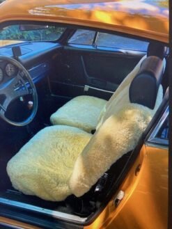 a classic Porsche 911. The car has a tan interior with sheepskin seat covers.