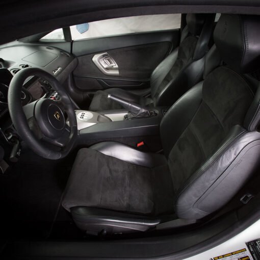 interior of a Lamborghini Gallardo. The car has black leather seats and a black steering wheel